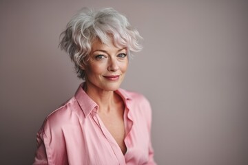 Wall Mural - Portrait of a beautiful senior woman with short gray hair and a pink shirt