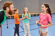 © LIGHTFIELD STUDIOS - A bearded man enthusiastically teaches a group of diverse children in a vibrant gymnasium, captivating their attention with engaging lessons.
