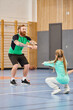 © LIGHTFIELD STUDIOS - A man and a little girl are immersed in physical education class in school gym