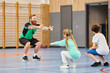 © LIGHTFIELD STUDIOS - A group of people enthusiastically engage in a physical education class in a school gym