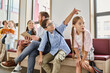© LIGHTFIELD STUDIOS - A group of children sits attentively on a bench while a male teacher instructs them in a bright, lively classroom setting.