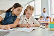 © LIGHTFIELD STUDIOS - Two young girls are sitting at a table, immersed in their books, as they focus on reading and learning.