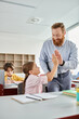 © LIGHTFIELD STUDIOS - A man stands beside a little girl in a vibrant classroom, engaging in a learning activity with a group of kids.