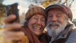 © LukaszDesign - Happy senior couple and selfie in nature garden for love, connection, and retirement in Australia. Older man, smile, and lady with social media, profile, and amusing photos