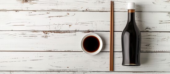 Fototapete - Chopsticks resting on a white wooden table beside a bottle of soy sauce creating a serene setting for a copy space image