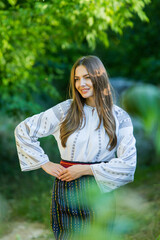 Wall Mural - Beautiful girl in traditional Romanian folk costume with embroidery. Woman traditional blouse. Romanian folklore