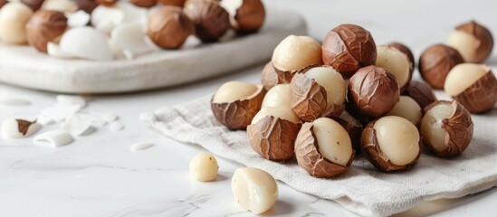 Fototapete - Macro view of whole unpeeled macadamia nuts with shelled kernels on a white background offering copy space image highlighting their nutritional value as a protein source