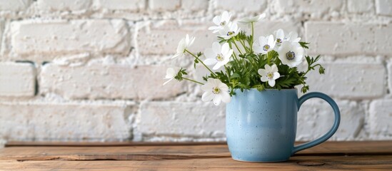 Wall Mural - white wild anemone flowers in a blue mug against a white brick wall on a wooden table evoke a rural 