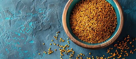 Aufkleber - Wooden bowl filled with bee pollen on a blue concrete background suitable for healthy nutrition with space for additional images