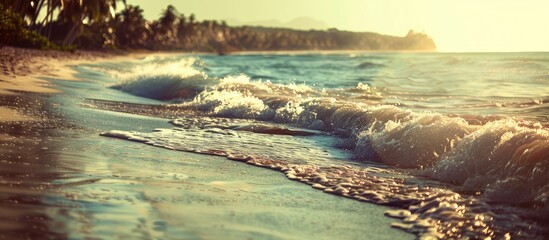 Poster - Tropical beach with sunlit waves creating an abstract background perfect as a copy space image for summer vacation and travel themes with a vintage filter