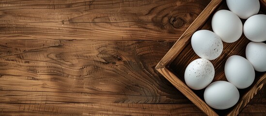 Poster - White eggs on a wooden table in a tray with copy space image