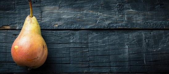 Fototapete - Top view of a pear on a black wooden table with a blank space for text or images. with copy space image. Place for adding text or design