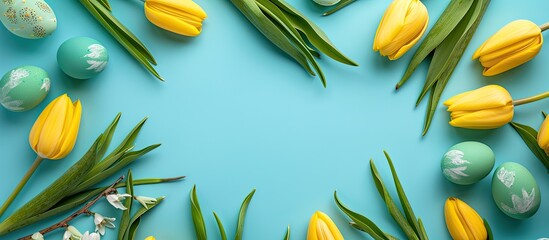 Poster - Flat lay with Easter eggs yellow tulips in a circle on a turquoise blue background creating a beautiful spring concept with room for additional content in the image