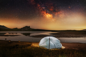 Wall Mural - Beautiful night landscape, camping on the small Lake and  mountains under bright Milky Way galaxy. 