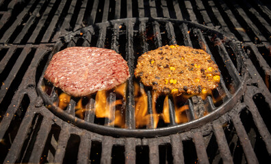 A grill with a raw animal based hamburger on the left and a plant based vegan hamburger on the right