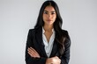 © Suchalitha - Portrait of a beautiful young Latin businesswoman, standing in a studio with a pure white background, with a confident and professional expression, arms folded, Generated AI