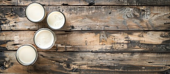 Sticker - Top view of milk and glasses on a wooden rustic table with copy space image