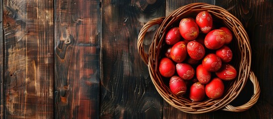 Wall Mural - Top view of a basket on a table filled with numerous red Easter eggs creating a vibrant display with copy space image