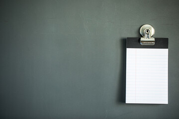 Lined note paper on dark gray magnet board