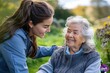 © BOTAHRY DEX - Female caregiver and senior woman in wheelchair picking wild flowers. Nurse and elderly woman enjoying a warm day in nursing home, public park.