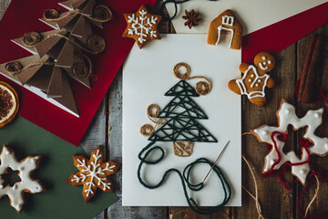 Wall Mural - Cute handmade origami postcard from recycled paper with anise star on wooden background. Homemade gingerbread cookies. Holiday craft, family tradition, quality time., simple easy do it yourself decor