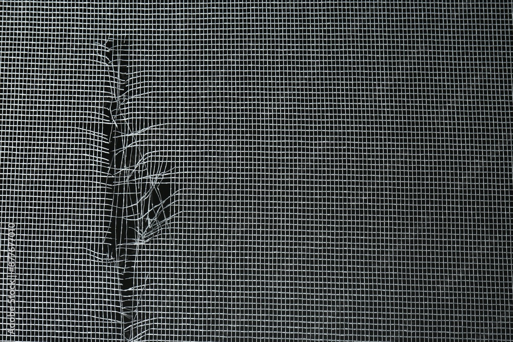Torn window screen against black background, closeup Stock Photo ...
