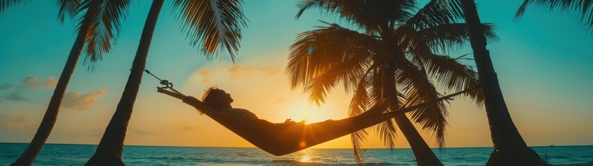 person relaxing in a hammock between palm trees on the beach