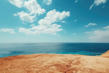 Wall Mural - A beautiful blue ocean with a few clouds in the sky. The sky is clear and the sun is shining brightly