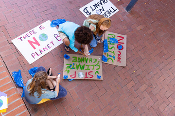 Wall Mural - Happy diverse schoolchildren making ecology posters during outdoor school art class