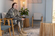 © Wavebreak Media - Sitting in waiting room, woman in undefined uniform with prosthetic leg smiling, copy space