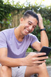 © Wavebreak Media - Smiling man using smartphone and sitting outdoors, enjoying leisure time