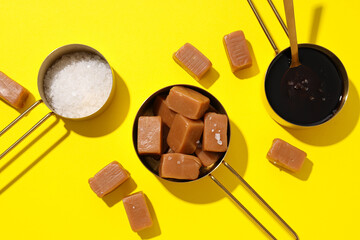 Sticker - Cubes of salted caramel with salt on a yellow background