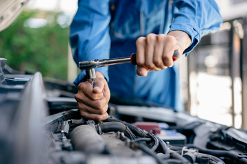 Wall Mural - close up of view Hand Auto mechanic repairman using a socket wrench working engine repair in the garage, change spare part, check the mileage of the car, checking and maintenance service concept.