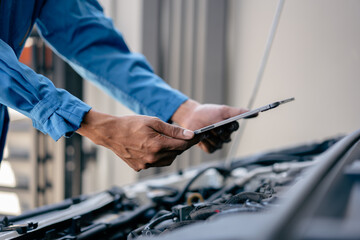 Wall Mural - Automotive mechanic repairman using tablet to checking engine room, check the mileage of the car, oil change, car auto service, auto maintenance service concept.