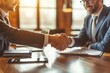 © Vera - Two young businessmen shaking hands at a desk, symbolizing the recruitment and hiring process in the business world.