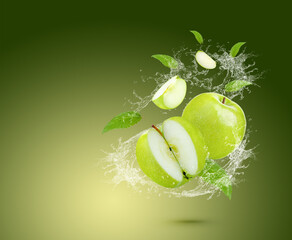 Wall Mural - Water splash on fresh green apple with leaves isolated on green background