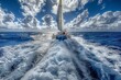 © RaptorWoman - A catamaran sailing through the open ocean, creating a trail of frothy waves under a partly cloudy sky.