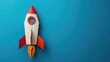 © AkuAku - Rocket paper craft taking off with copy space on a blue background symbolizing back to school