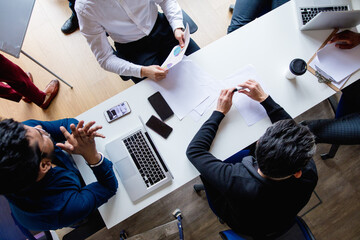 Canvas Print - High angle view of businessmen discussing at white table in office