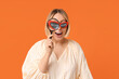 © Pixel-Shot - Surprised adult woman in eyeglasses with words WOW holding magnifying glass on orange background