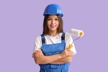 Wall Mural - young female painter with roller on lilac background