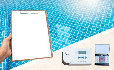 Poster - Digital water tester with blank clipboard in girl hand over clear swimming pool water background, quality water tester on pool edge, service and maintenance industry