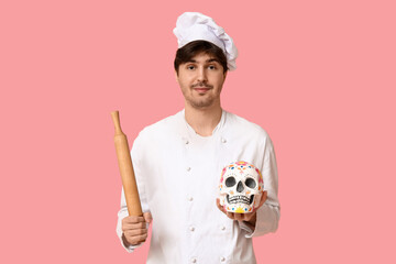 Sticker - Young male chef with rolling pin and painted human skull on pink background