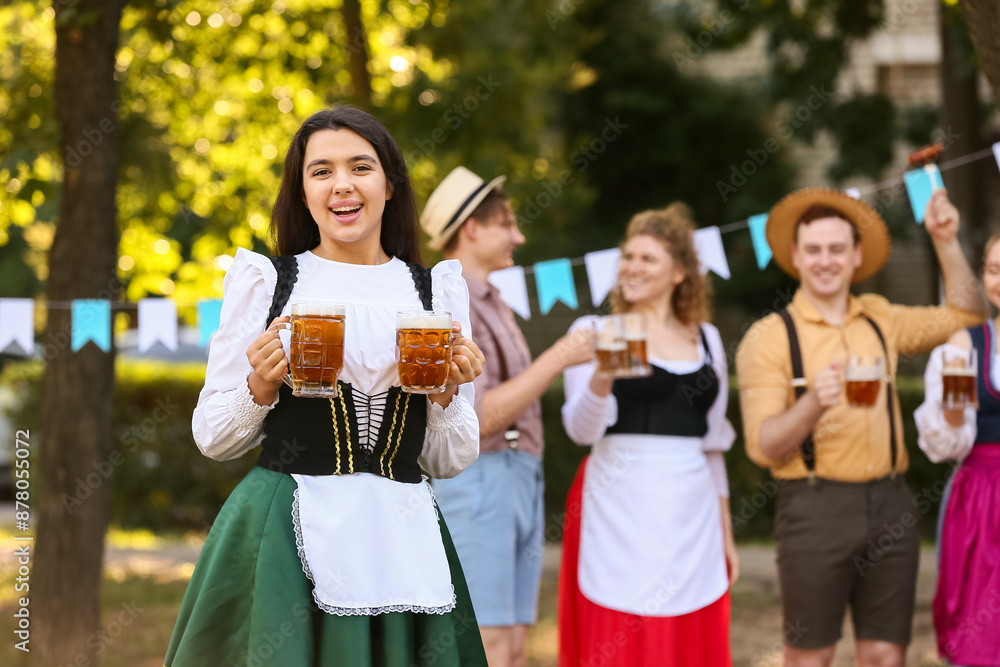 Young Octoberfest waitress with beer outdoors