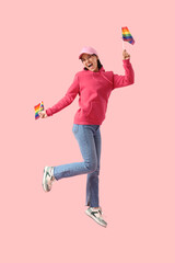 Wall Mural - Happy young woman with LGBT flags on pink background