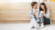 © Prostock-studio - A young couple sits on the floor in a modern kitchen, enjoying a coffee break together. They are both smiling and looking at each other, enjoying their shared moment, copy space