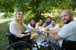 © Robert Kneschke - Inclusive friends enjoying a picnic with person in wheelchair
