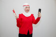 © Stora Space - Woman in white hijab wearing red sweater. celebrating Indonesia's independence day. holding a flag and taking a selfie with a cellphone. isolation on white background.