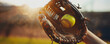 © BraveSpirit - Close-up of a softball glove catching a ball during a game at sunset