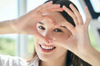 © puhhha - Smiling Woman Framing Eye With Hands In Heart Shape, Representing Eye Care And Eye Health.